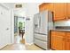 Modern kitchen with stainless steel refrigerator and warm wood cabinets at 4401 Abaco Dr, Tavares, FL 32778