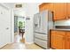 Well lit kitchen shows modern refrigerator and cabinets with a view into a dining area at 4401 Abaco Dr, Tavares, FL 32778