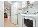 Functional laundry room with modern washer and dryer units, plus overhead cabinets for storage at 4401 Abaco Dr, Tavares, FL 32778