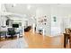 Expansive living room with hardwood floors, a large TV, a white piano, and modern lighting fixtures at 4401 Abaco Dr, Tavares, FL 32778