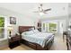 Spacious main bedroom with hardwood floors, fan, en-suite bath, and natural light from the bay window at 4401 Abaco Dr, Tavares, FL 32778
