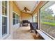 Covered back patio featuring a ceiling fan, string lights, a grill and a bench for outdoor relaxation at 4401 Abaco Dr, Tavares, FL 32778