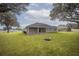 Spacious backyard featuring a built-in fire pit and mature trees at 5005 County Road 125B1, Wildwood, FL 34785