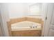 Garden tub surrounded by tile, and natural light from block-glass window at 5005 County Road 125B1, Wildwood, FL 34785