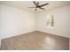 Bright bedroom featuring gray wood-look flooring, a ceiling fan, and natural light from a shuttered window at 5005 County Road 125B1, Wildwood, FL 34785