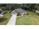 Well-kept single-story home featuring a manicured lawn, mature trees, and an attached two-car garage at 5005 County Road 125B1, Wildwood, FL 34785