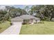 Charming single-story home with a well-maintained lawn, mature trees, and an attached two-car garage at 5005 County Road 125B1, Wildwood, FL 34785