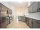 Modern kitchen featuring gray cabinets, quartz countertops, and stainless steel appliances at 5005 County Road 125B1, Wildwood, FL 34785