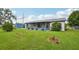 Well-maintained backyard with lush green lawn, small garden, storage shed and screened-in porch at 550 Floral Dr, Kissimmee, FL 34743