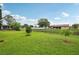 Green lawn with small garden beds, fence, and views of the neighborhood at 550 Floral Dr, Kissimmee, FL 34743