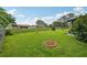 Spacious backyard featuring a lush green lawn, small plants, and a screened-in porch at 550 Floral Dr, Kissimmee, FL 34743