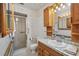 Well-lit bathroom with shower, toilet, and vanity with wood cabinets at 550 Floral Dr, Kissimmee, FL 34743