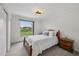 Cozy bedroom features a wooden bed frame, plush carpeting, and a bright window view at 550 Floral Dr, Kissimmee, FL 34743