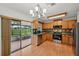 Kitchen with wood cabinets, tile backsplash, stainless steel appliances, and sliding door to patio at 550 Floral Dr, Kissimmee, FL 34743