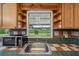 Kitchen sink with tile countertops and backsplash with a view of the fenced backyard at 550 Floral Dr, Kissimmee, FL 34743