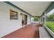 Outdoor screened patio with tiled floor and bench seating, ideal for enjoying the backyard view at 550 Floral Dr, Kissimmee, FL 34743