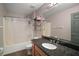 Bathroom featuring a granite countertop, a bathtub with shower, and neutral-toned walls at 6001 Pine Bluff Ln, Mascotte, FL 34753