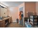 Functional bathroom with a single sink vanity, tiled floors, and gray door with towel hooks at 6001 Pine Bluff Ln, Mascotte, FL 34753