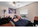 This bedroom has a dark blue comforter, wood floors and a large window for natural light at 6001 Pine Bluff Ln, Mascotte, FL 34753
