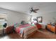 Inviting bedroom features a large bed with colorful bedding, wood floors, and a ceiling fan at 6001 Pine Bluff Ln, Mascotte, FL 34753