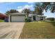 Charming single-story home featuring a well-manicured lawn and attached two car garage at 6001 Pine Bluff Ln, Mascotte, FL 34753