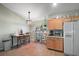 Bright eat-in kitchen area with wood cabinets, tile flooring, window views, and natural lighting at 6001 Pine Bluff Ln, Mascotte, FL 34753