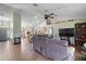 Open-concept living room featuring a large sectional sofa, modern ceiling fan, and tile flooring throughout at 6001 Pine Bluff Ln, Mascotte, FL 34753
