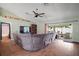 Living area featuring a large sectional sofa, neutral walls, and a sliding glass door with access to the outside patio at 6001 Pine Bluff Ln, Mascotte, FL 34753