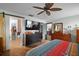 This main bedroom has a barn door to the bathroom, TV, walk-in closet and wood flooring at 6001 Pine Bluff Ln, Mascotte, FL 34753