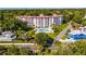 Picturesque aerial view of a multi-story condo building nestled among trees with a bright blue pool in the front yard at 601 N Mcdonald St # 2, Mount Dora, FL 32757