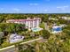 Aerial view of a beautiful condo building, pool, and a charming small town, all nestled in the lush greenery of Florida at 601 N Mcdonald St # 2, Mount Dora, FL 32757