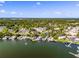 Panoramic aerial shot of a lakeside community featuring condos, waterfront houses, and a vast expanse of trees under a sunny sky at 601 N Mcdonald St # 2, Mount Dora, FL 32757
