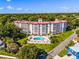 Stunning aerial view of the condo building with a red roof, surrounded by lush greenery and a sparkling blue community pool at 601 N Mcdonald St # 2, Mount Dora, FL 32757