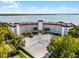 Waterfront condo building featuring a red tile roof, well-maintained landscaping, and ample parking at 601 N Mcdonald St # 2, Mount Dora, FL 32757