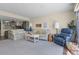 Inviting living room with comfortable floral sofas, a recliner, and a partial view of the kitchen at 601 N Mcdonald St # 2, Mount Dora, FL 32757