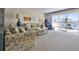 Cozy living room with plush seating, neutral carpeting, and a sunny balcony with outdoor chairs at 601 N Mcdonald St # 2, Mount Dora, FL 32757