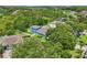 Aerial view of single Gathering home with fenced yard, mature trees and a pool in a residential neighborhood at 6048 Tremayne Dr, Mount Dora, FL 32757