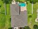Aerial view of the property showcasing its roof, manicured lawn, pool, and serene backyard at 6048 Tremayne Dr, Mount Dora, FL 32757