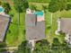 Aerial shot displays the house surrounded by well manicured lawn, pool, and mature trees at 6048 Tremayne Dr, Mount Dora, FL 32757
