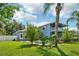 An exterior view of the two-story blue home overlooking a large lush green lawn at 6048 Tremayne Dr, Mount Dora, FL 32757