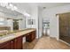 Bathroom with dual sinks, granite counters, and tile flooring at 6048 Tremayne Dr, Mount Dora, FL 32757
