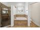Bathroom features a glass enclosed shower and a separate tub beneath a window at 6048 Tremayne Dr, Mount Dora, FL 32757