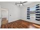 This bedroom features hardwood floors, and a bright window with modern curtains at 6048 Tremayne Dr, Mount Dora, FL 32757
