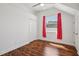 Bright bedroom with wood floors, red curtains, a closet, and a ceiling fan at 6048 Tremayne Dr, Mount Dora, FL 32757