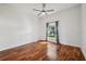 Bedroom with hardwood flooring and a ceiling fan, brightened by a window with curtains at 6048 Tremayne Dr, Mount Dora, FL 32757