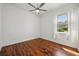 Bright bedroom with hardwood flooring and a ceiling fan, complemented by a window with curtains at 6048 Tremayne Dr, Mount Dora, FL 32757