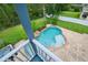 Overhead view of backyard pool with rock waterfall feature, in ground pool with custom paver surround at 6048 Tremayne Dr, Mount Dora, FL 32757