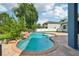 A lush backyard pool with a rock waterfall feature that brings a peaceful vibe at 6048 Tremayne Dr, Mount Dora, FL 32757