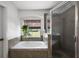 Bathroom features soaking tub, shower with glass enclosure, and window with view at 621 Lost Grove Cir, Winter Garden, FL 34787