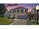 Charming two-story home featuring a manicured lawn, brick driveway, and inviting front porch at 621 Lost Grove Cir, Winter Garden, FL 34787